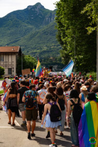 Persone in corteo con bandiera arcobaleno e gay