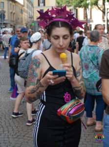 Una persona che mangia un gelato e guarda il telefono