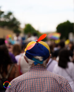 Un anziano con un cappellino con la girandola, visto di spalle